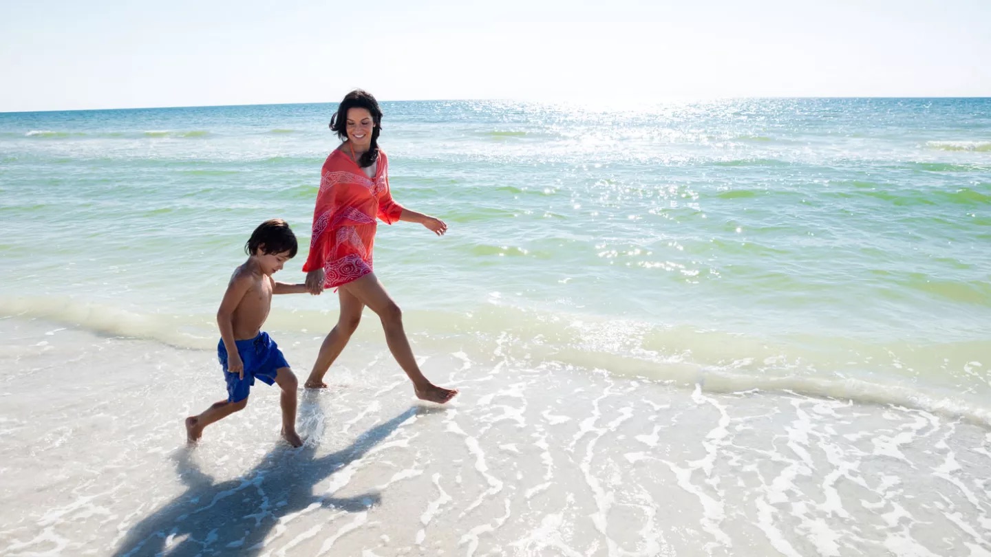 A-woman-walks-on-the-beach-with-her-young-son-in-N.jpeg