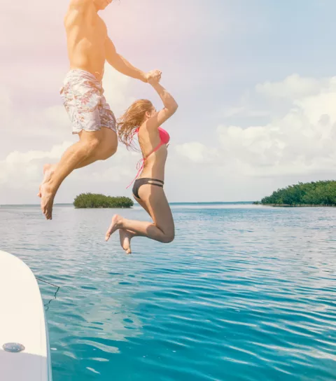 Couple jumping off a boat