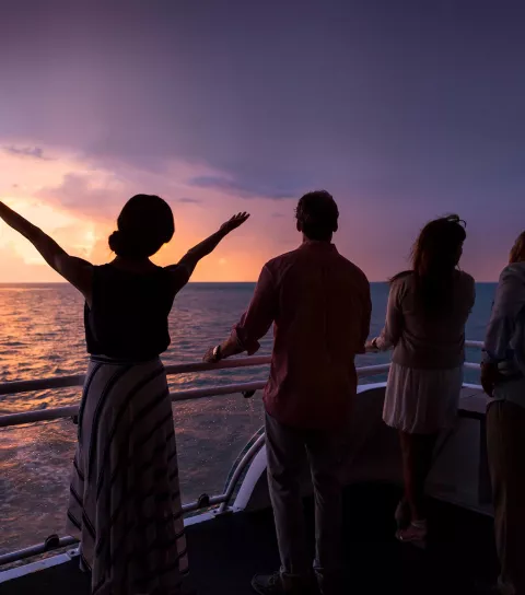 Group of meeting attendees on ship at sunset