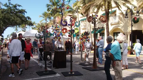 An art show takes place in a crowded street.