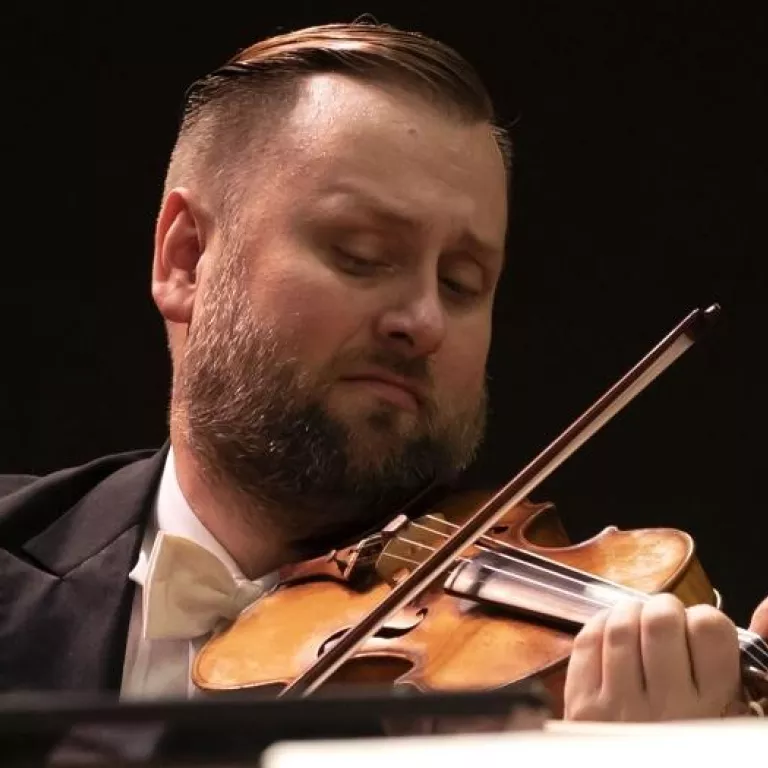 Image of Zachary DePue of the Naples Philharmonic on stage playing violin during a performance Photo