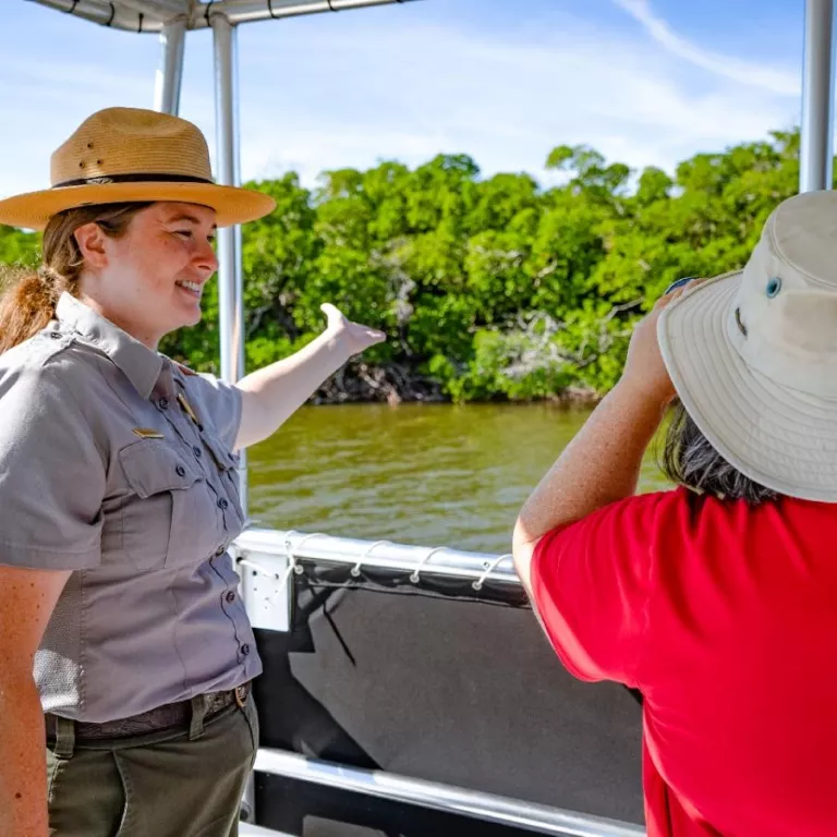 Guide pointing out wildlife on boat tour Photo 2