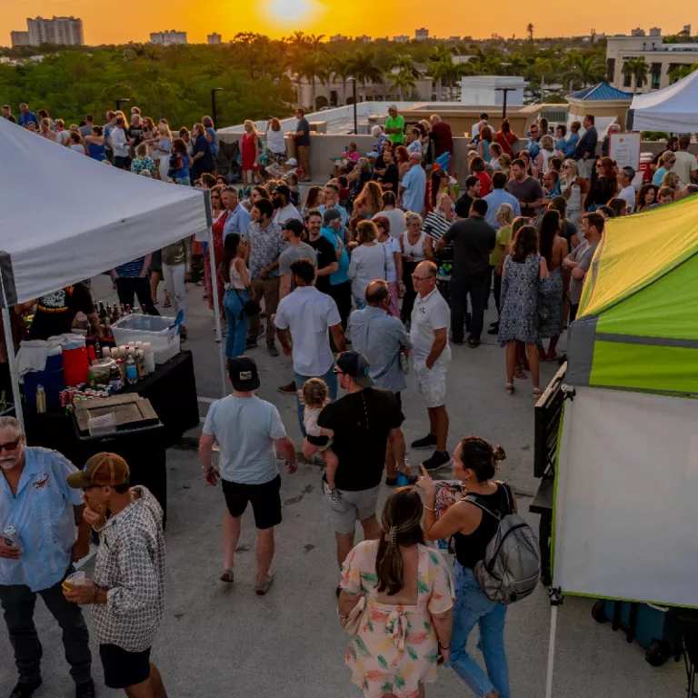 a crowd of people enjoy a Florida sunset on the rooftop of the parking garage Photo