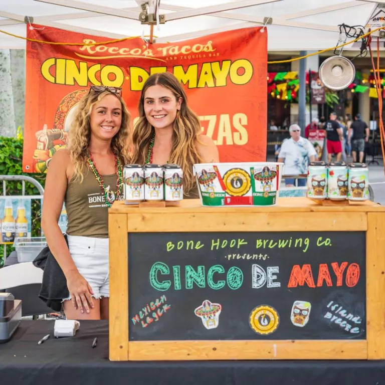 two girls standing at bar serving drinks for cinco Photo
