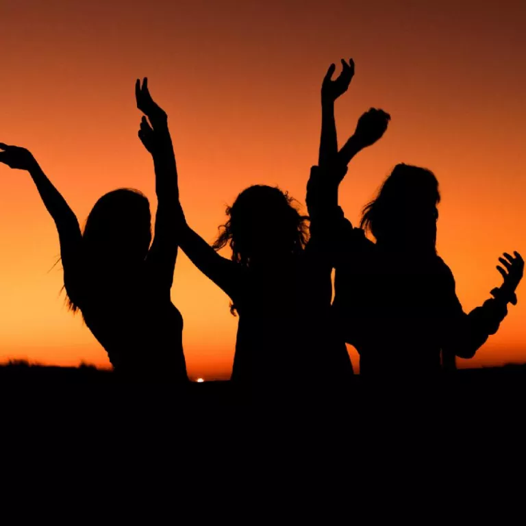 Three people in front of sunset Photo