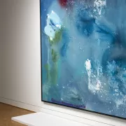 A woman looks at a piece of art in a gallery.