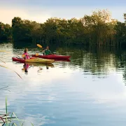 Two kayakers on the water at sunset