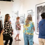 People in an art gallery looking and black and whi