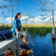 A woman sits on a dock during a hike in the Evergl