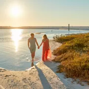 A couple holds hands at Tigertail Beach at sunset