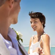 bride smiles at groom on beautiful beach