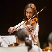 A member of the Naples Philharmonic Youth Orchestra playing the violin Photo