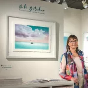Niki Butcher leaning on a table in her exhibit Photo