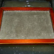 paper making frame framed against paper pulp Photo