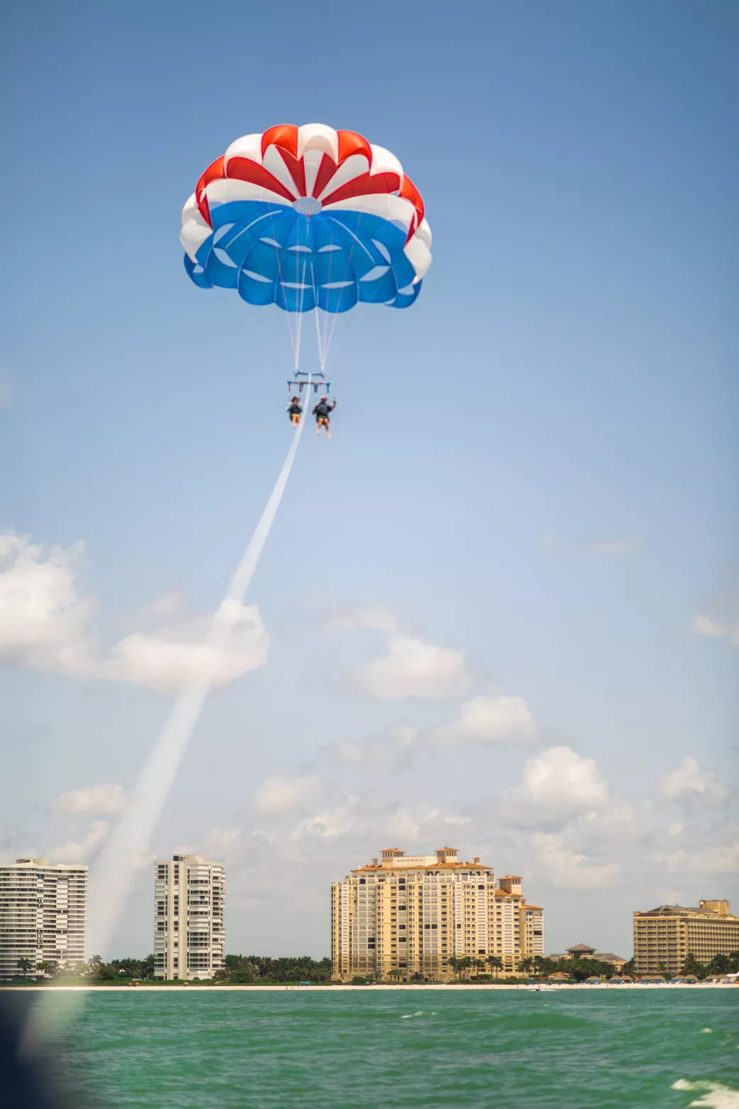 Couple parasailing with skyline of buildings