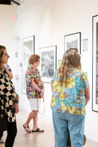 People in an art gallery looking and black and whi