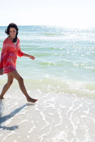 A woman walks on the beach with her young son in N