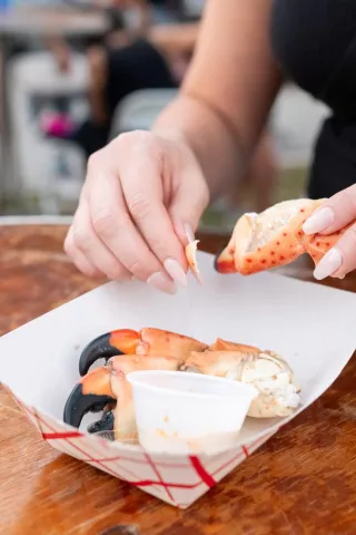 Person handling stone crab claws on plate