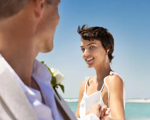 bride smiles at groom on beautiful beach