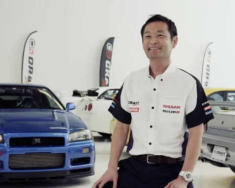 kazuki furusawa smiles in front of his car collection