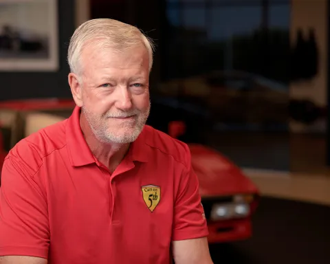 tom o'riordan grins into the camera in cars on 5th shirt
