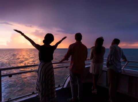 Group of meeting attendees on ship at sunset