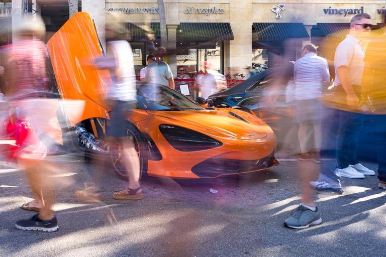 crowd walks by impressive cars at cars on fifth event