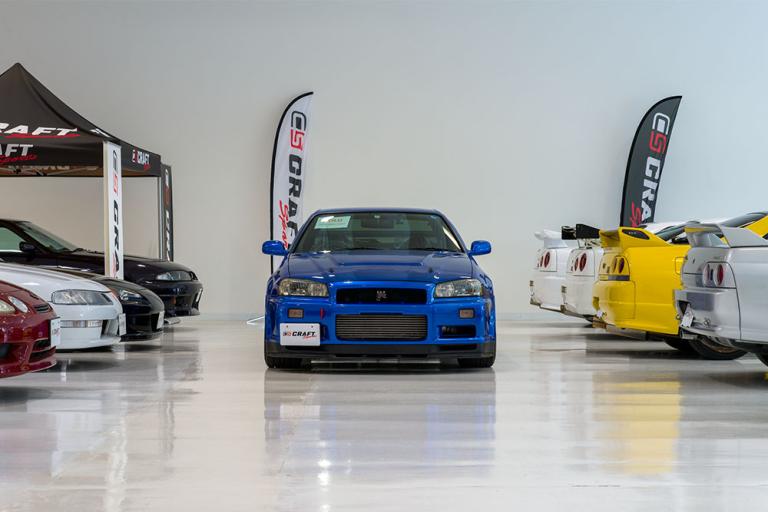 front of a blue GT-R in the CRAFT SPORTS showroom